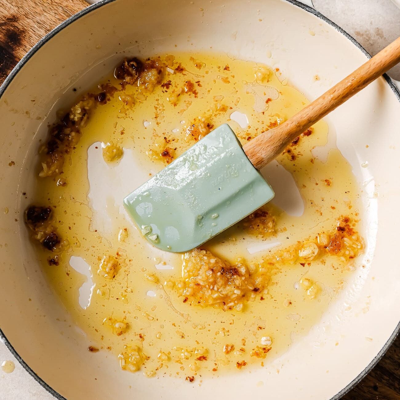 Olive oil and garlic in a large white skillet.