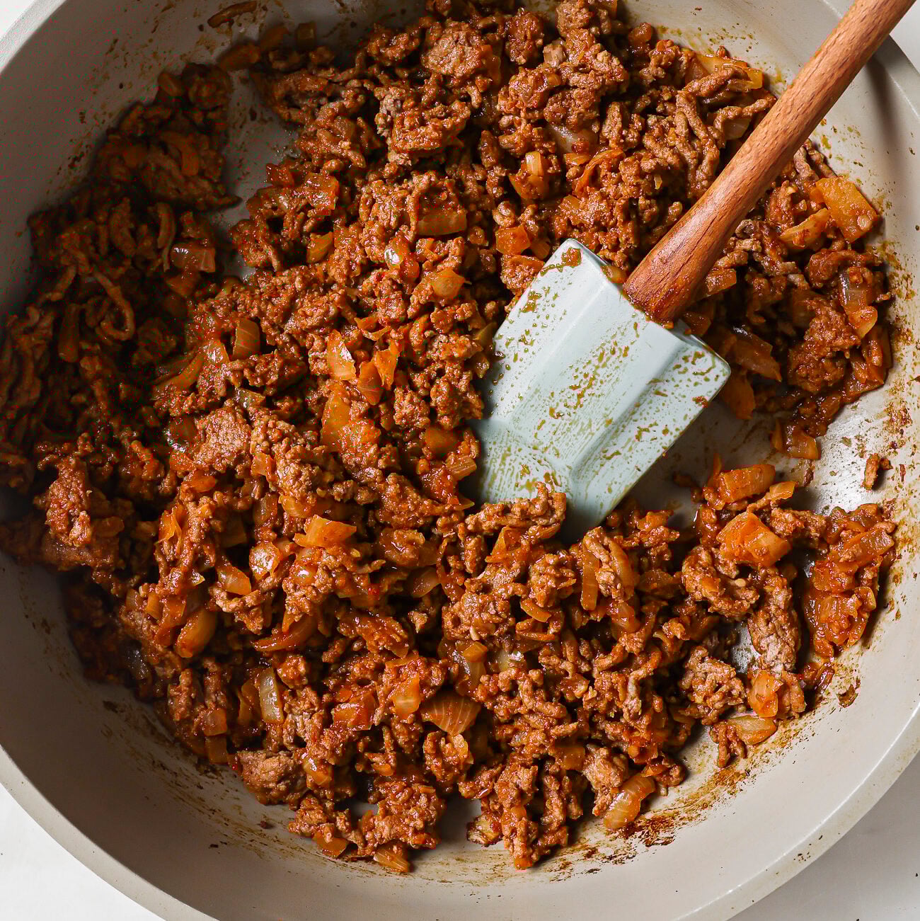 A bowl of ground meat with a spatula, ready to become the hearty base for your favorite Slow Cooker Chili Recipe.