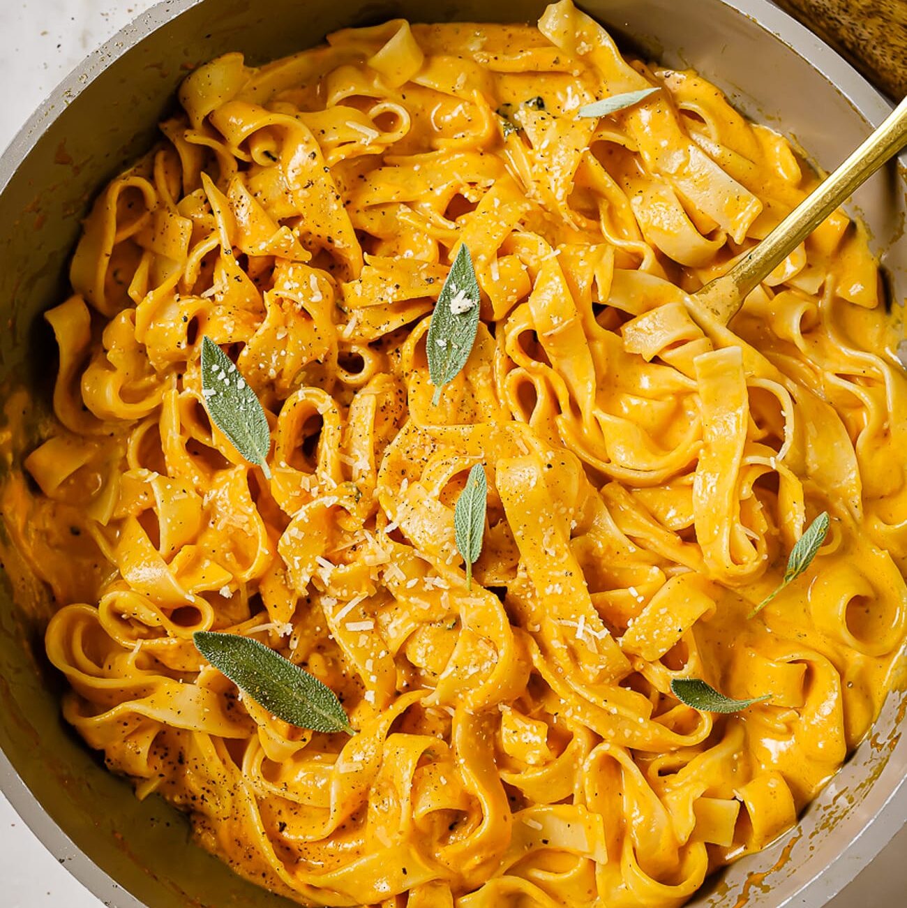 Pumpkin alfredo sauce and fetucchini noodles garnished with sage.