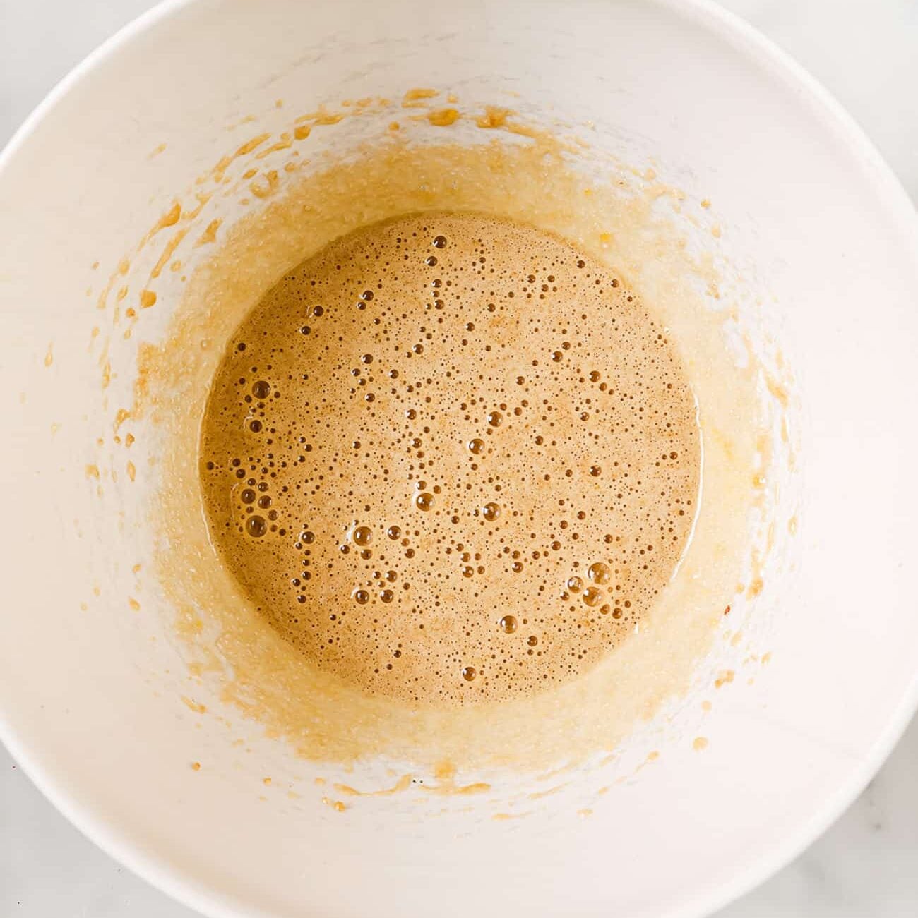 The milk and sugar whisked together in a white bowl.