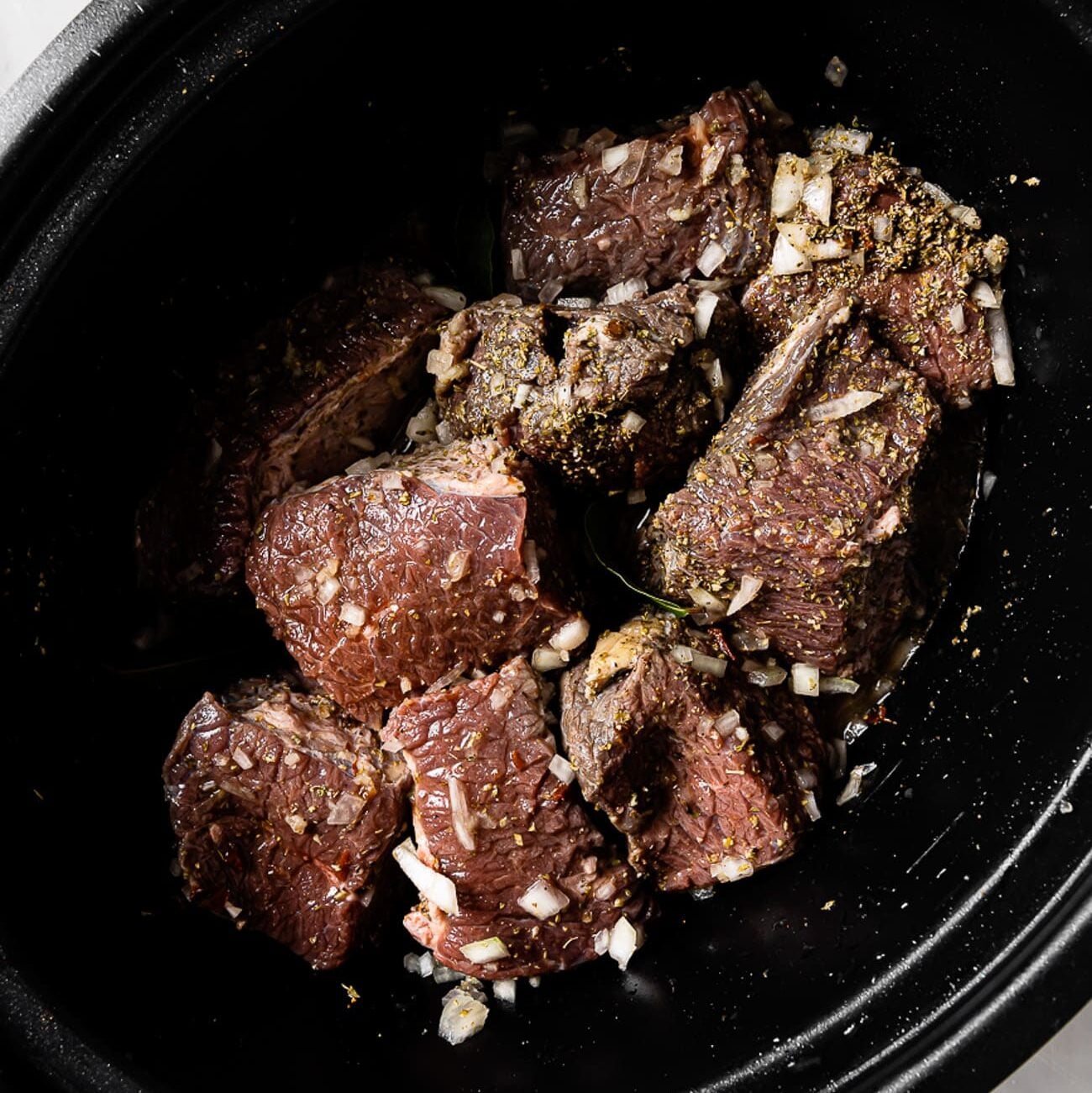 Beef tossed in seasonings and bay leaves added.